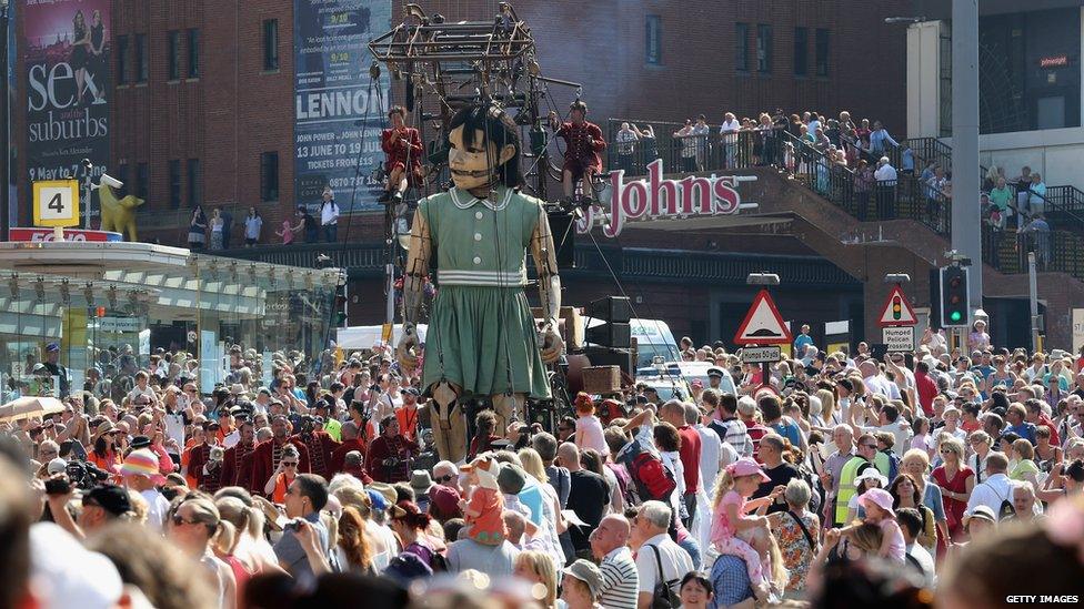 A giant marionette girl walks through Liverpool