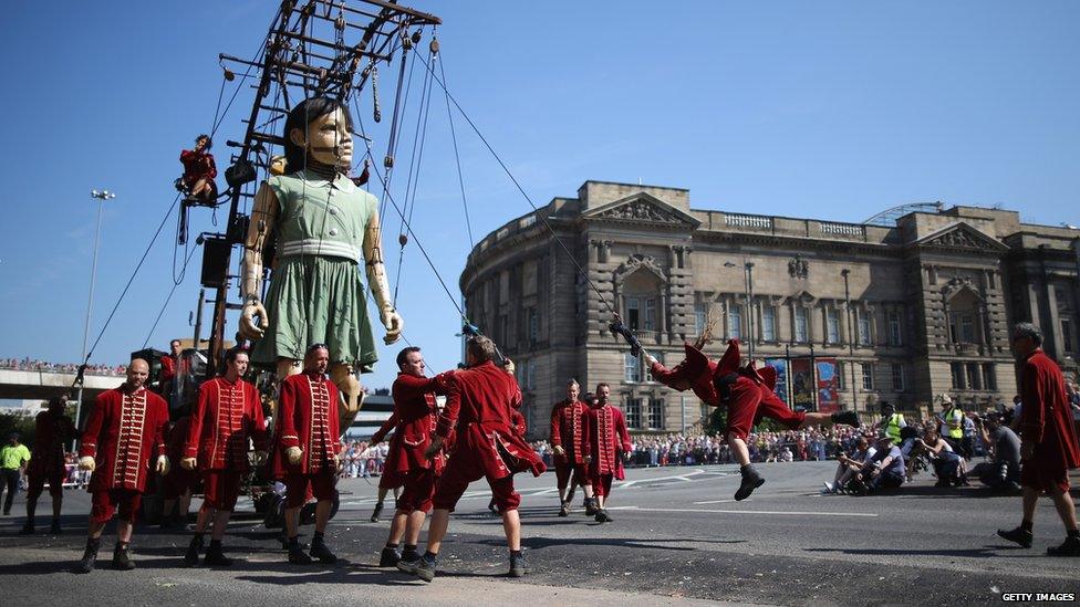 A giant marionette girl walks through Liverpool