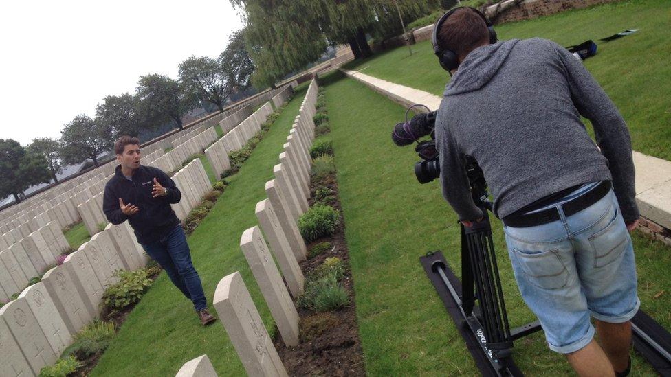 Ricky speaks to the camera as he walks through a row of gravestones