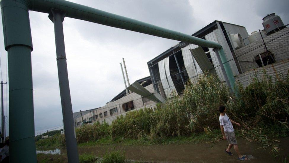 Man walks at the rear of the damaged factory, 2 Aug