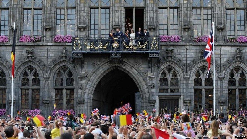 Prince Harry, Mons city mayor Nicolas Martin, Prince William and the Duchess of Cambridge appear on a balcony at the Mons townhall with Belgium's outgoing Prime Minister Elio Di Rupo