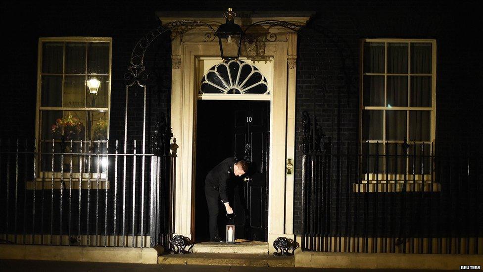 A lantern being placed at the front door of Number 10 Downing Street