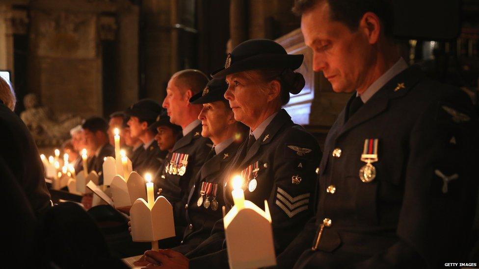 The congregation at a service in Westminster Abbey hold candles