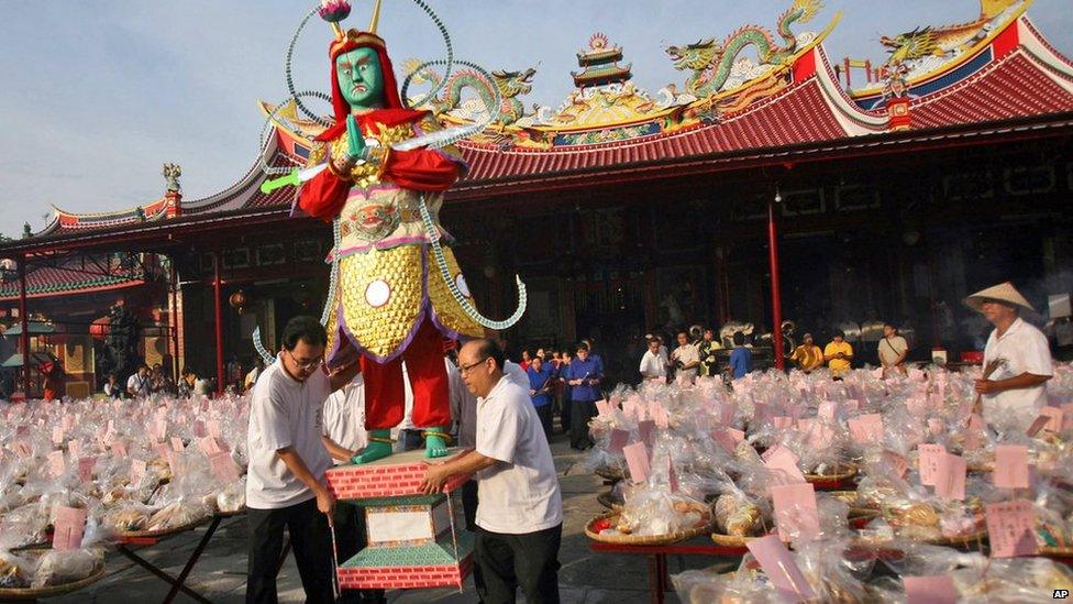 Ethnic-Chinese Indonesians carry an effigy of the "king of ghost" during the "hungry ghost" festival in Medan, North Sumatra, Indonesia, on Sunday, 10 August, 2014