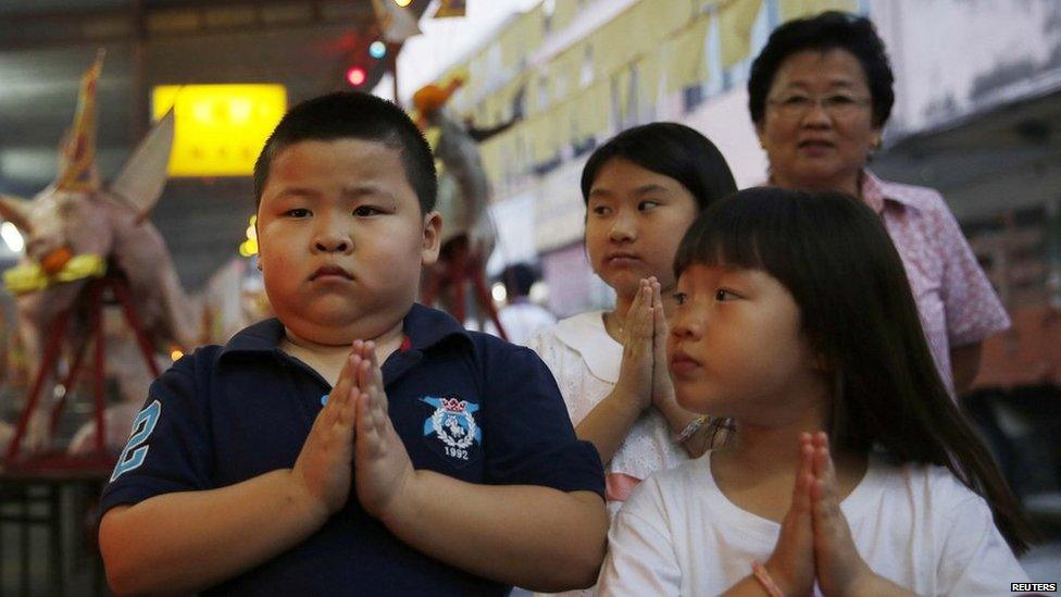 Children pray during the Hungry Ghost festival in Kuala Lumpur on 3 August, 2014