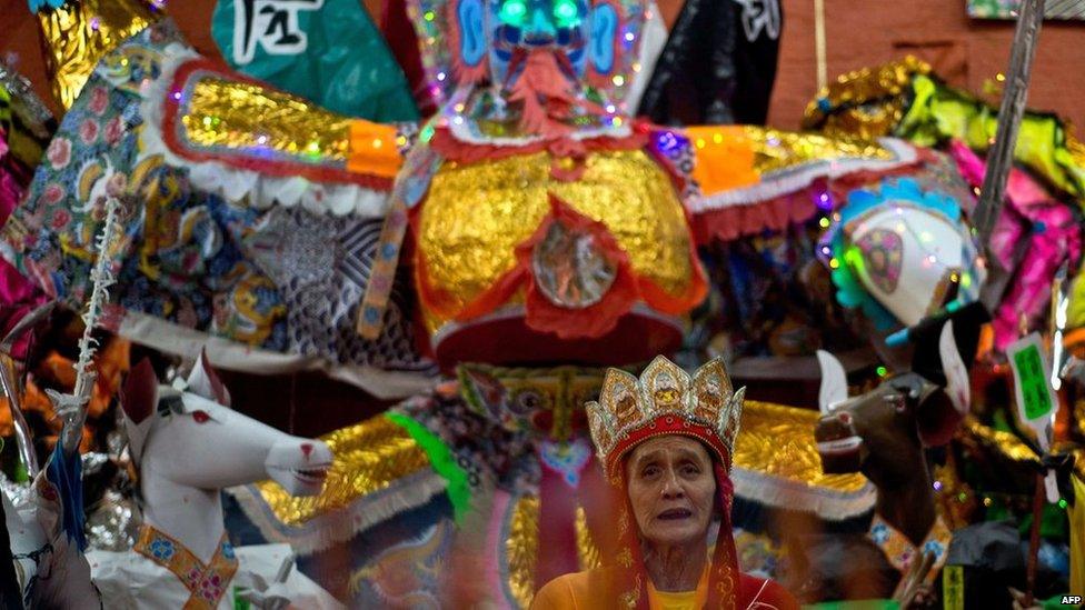 An ethnic Chinese priest offers prayers in front of the statue made of paper of Chinese deity "Da Shi Ye" or Guardian God of Ghosts during the Hungry Ghost festival in Kuala Lumpur, late on 10 August, 2014