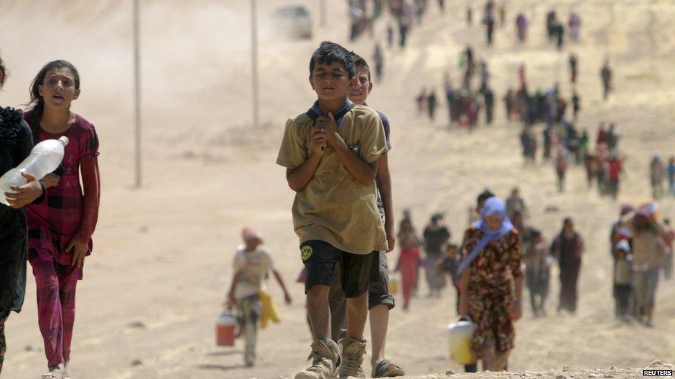 Children from the minority Yazidi sect, fleeing violence from forces loyal to the Islamic State in Sinjar town, make their way towards the Syrian border, on the outskirts of Sinjar mountain, near the Syrian border town of Elierbeh of Al-Hasakah Governorate August 10, 2014