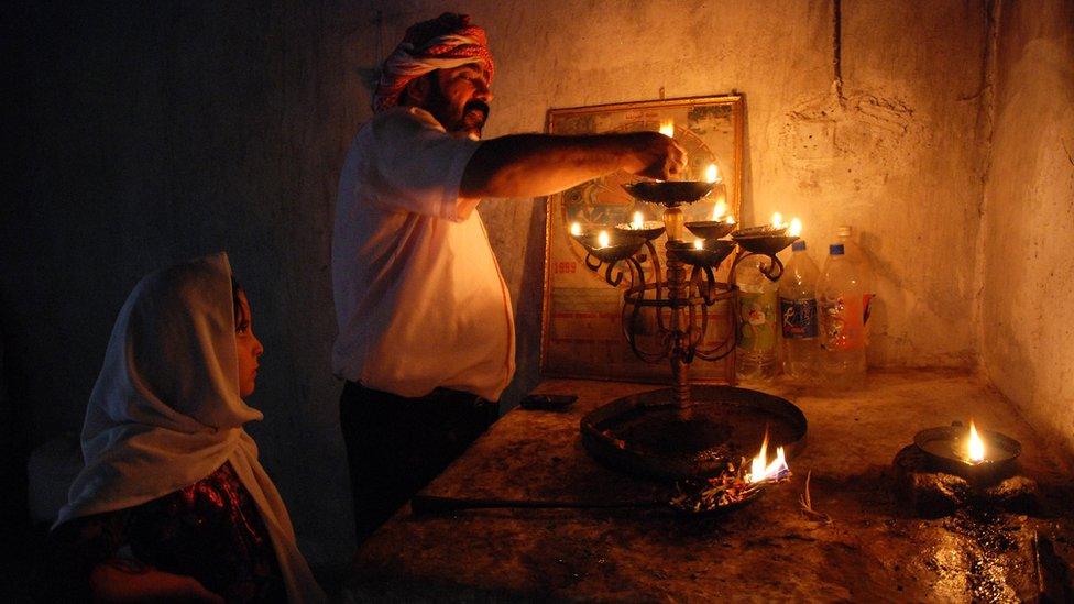 Candle lighting at a Yazidi home shrine