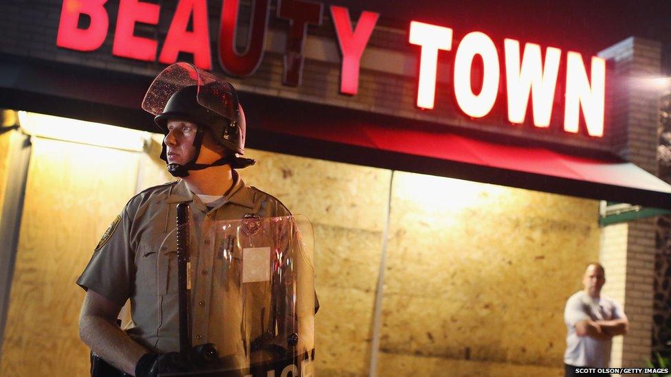 Police stand guard before the mandatory midnight curfew on August 16, 2014 in Ferguson, Missouri
