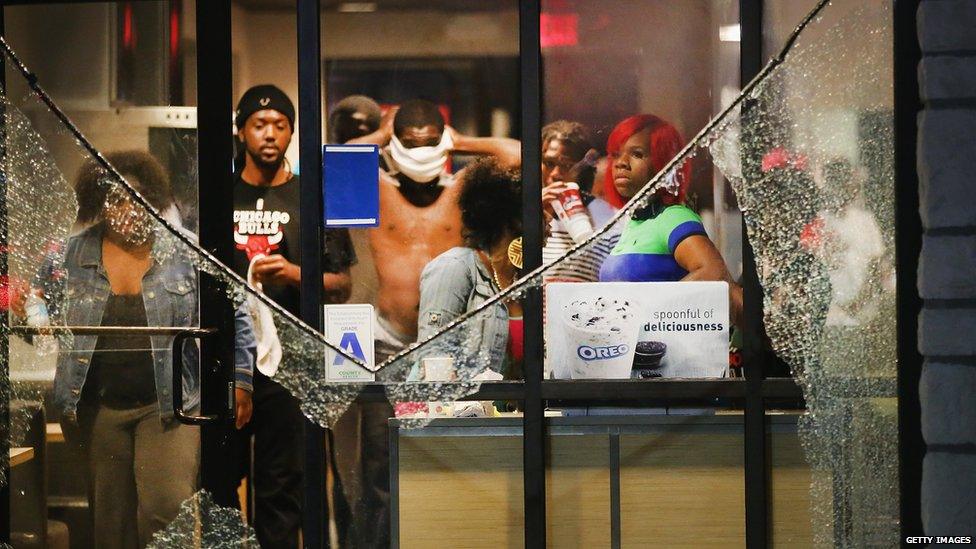 People take cover from tear gas inside a McDonald's restaurant after a demonstration in Ferguson, Missouri, 17 August 2014