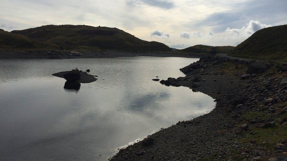 Llyn Llydaw yn llonydd er gwaetha'r tywydd llwm