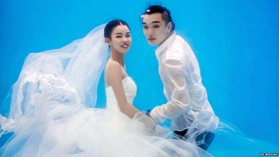 Bride and groom-to-be having their wedding photos taken underwater