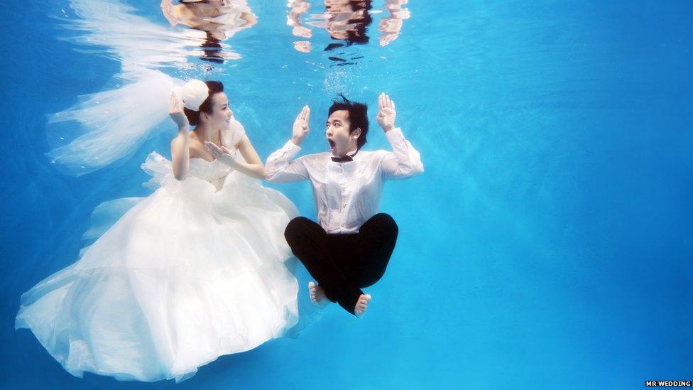 Bride and groom-to-be having their wedding photos taken underwater