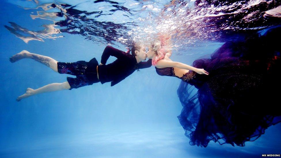 A couple kiss underwater