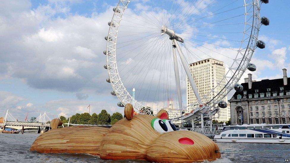 Giant hippo sculpture floats past the London Eye