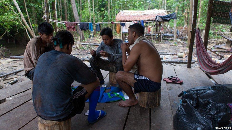 Loggers play cards at a camp built by in the Peruvian jungle, on the shores of the of the Esperanza river on 3 April 2013.