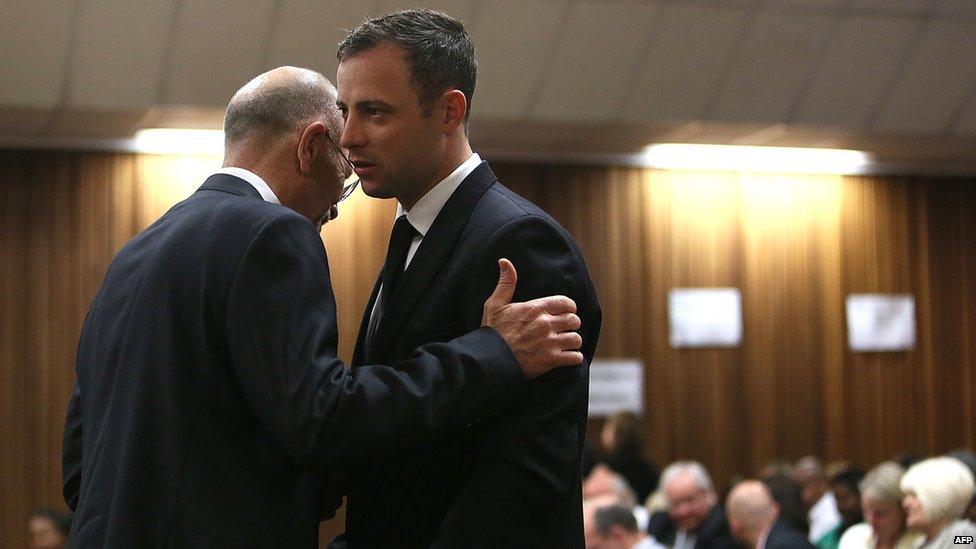 Paralympic track star Oscar Pistorius (right) chats to his uncle Arnold ahead of judgment in his murder trial at the High Court in Pretoria on 12 September 2014