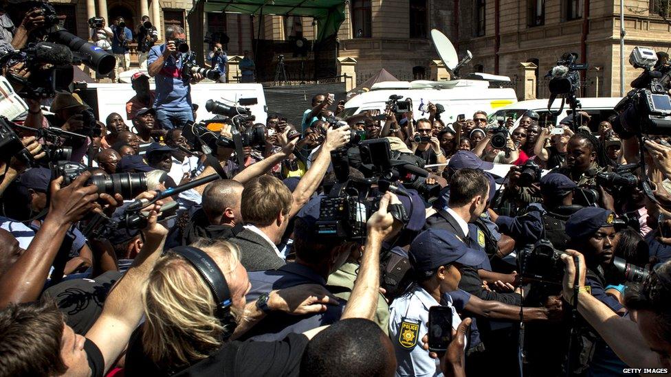 Media swarm around Oscar Pistorius as he leaves on bail from the North Gauteng High Court in Pretoria, South Africa, 12 September 2014