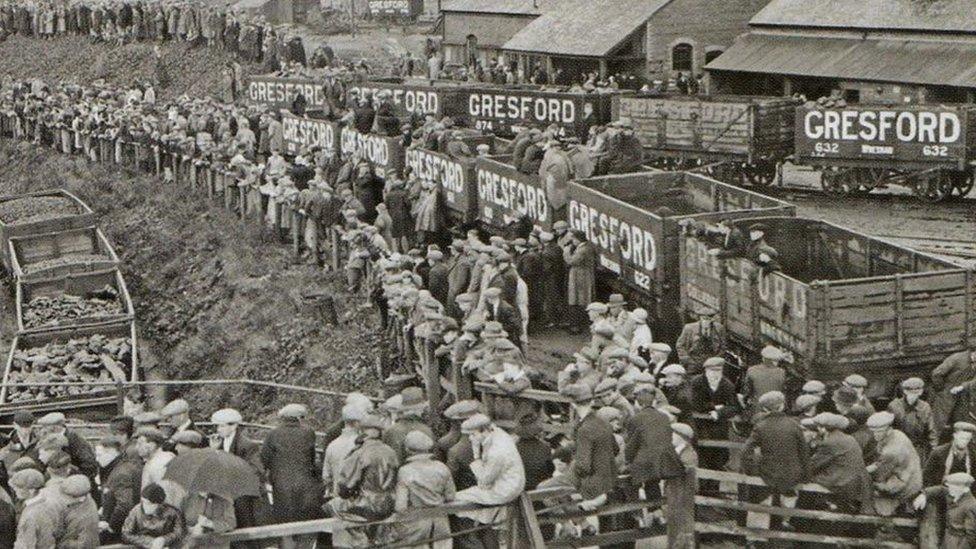 Yn yr oriau wedi'r drychineb, ymgasglodd torf fawr o berthnasau a glowyr wrth geg y pwll i aros am newyddion / In the hours following the tragedy, large crowds of concerned relatives and miners gathered at the pit head waiting for news