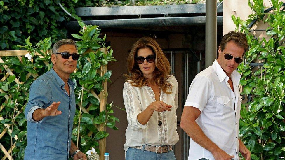 George Clooney (L), US model Cindy Crawford (C) and her husband Rande Gerber (R) stand up after eating breakfast at the Cipriani Hotel, in Venice