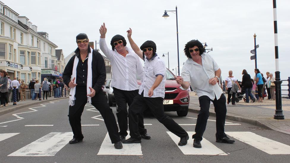 Four Elvis lookalikes on a road crossing