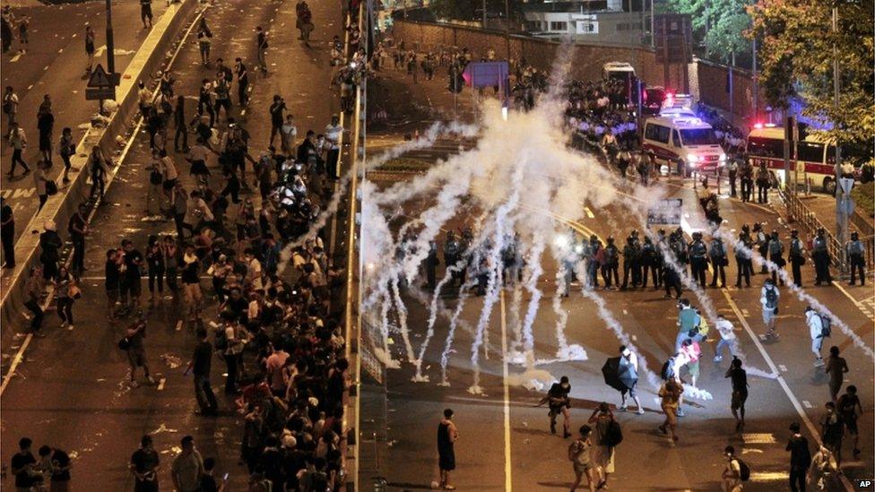 Riot police fire tear gas on student protesters occupying streets surrounding the government headquarters in Hong Kong, early Monday, 29 September 2014.