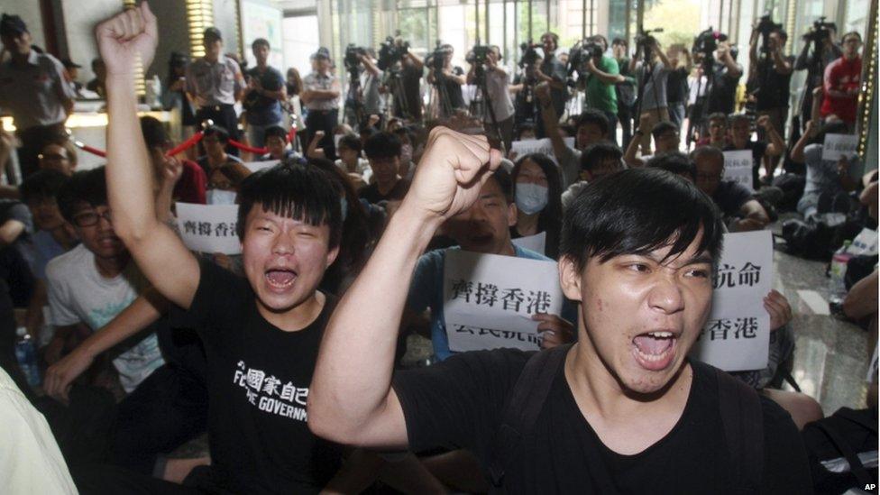 Hong Kong and Taiwanese student demonstrators shout slogans in support of pro-democracy protests taking place in Hong Kong at the Hong Kong Economic, Trade and Cultural Office in Taipei, Taiwan, Monday, 29 Sept, 2014.