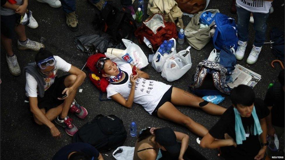 Protesters lie down to block the main street to the financial Central district in front of the government headquarters in Hong Kong, on 29 September 2014.