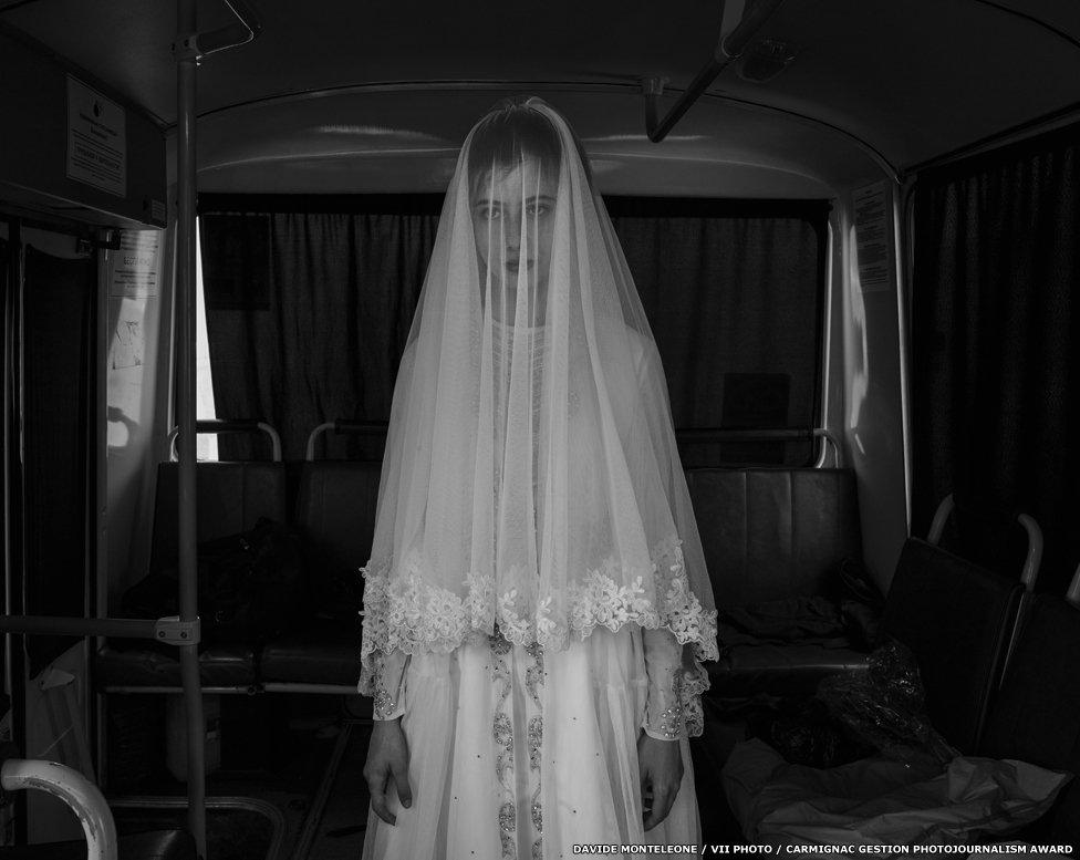 Rada, age 14, trying on a wedding dress designed by her sister, on board a bus during the rehearsal for the shooting of a movie on Chechen deportation.