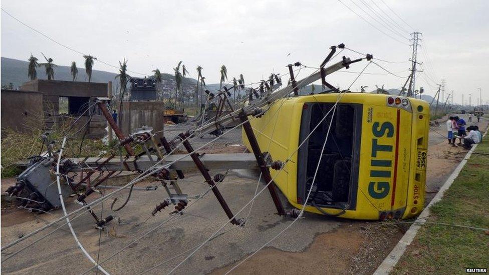 Power lines and a passenger bus are seen after being damaged by strong winds caused by Cyclone Hudhud in the southern Indian city of Visakhapatnam, October 13, 2014.