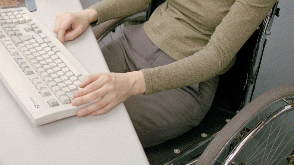 Woman in a wheelchair using a computer