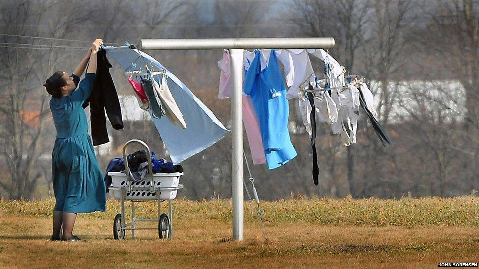 An Amish housewife hanging laundry