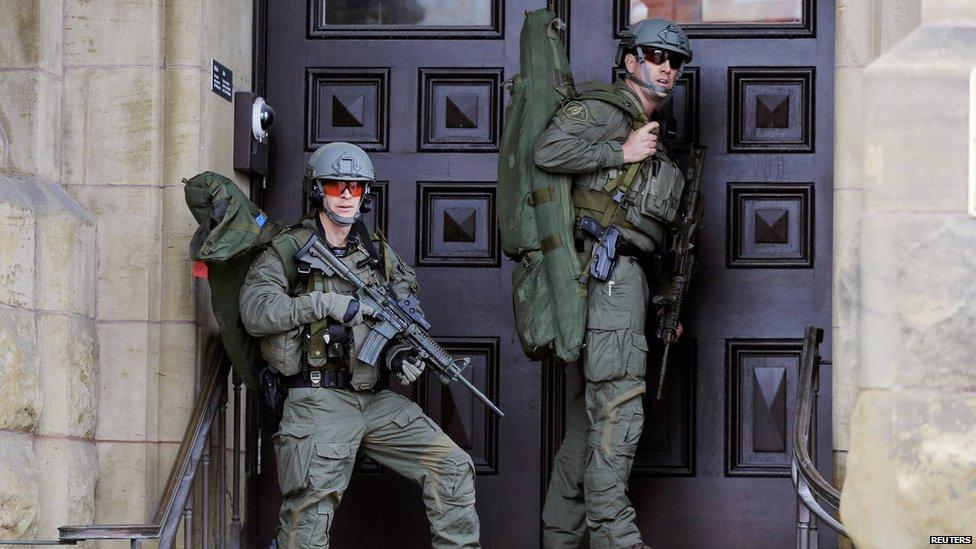 Armed RCMP officers guard the front of Langevin Block on Parliament Hill