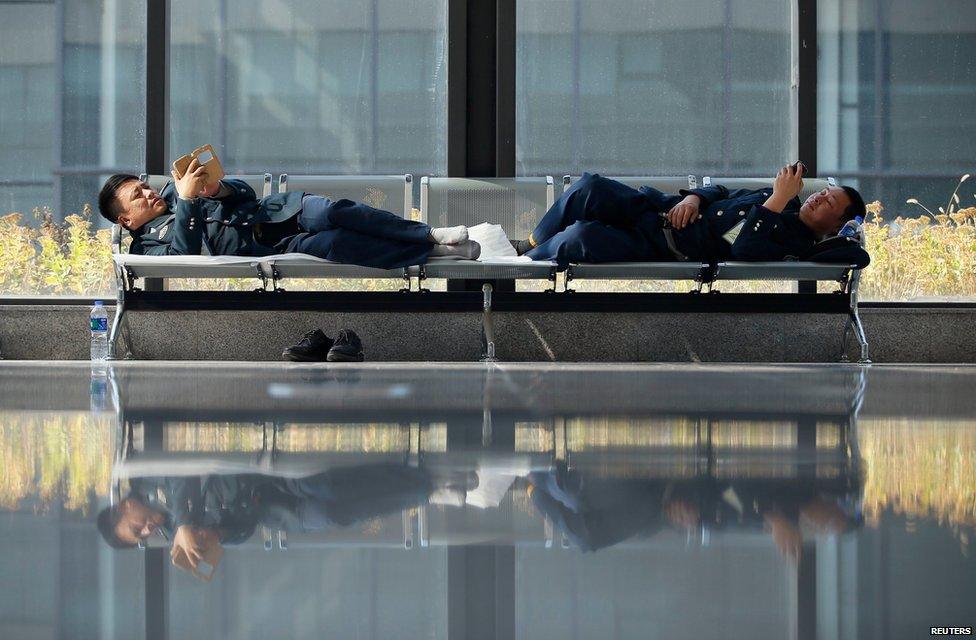 Security personnel check their mobile phones