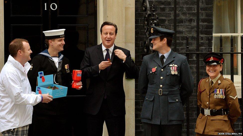 British Prime Minister David Cameron buys a poppy outside Number 10 to mark this year's appeal.