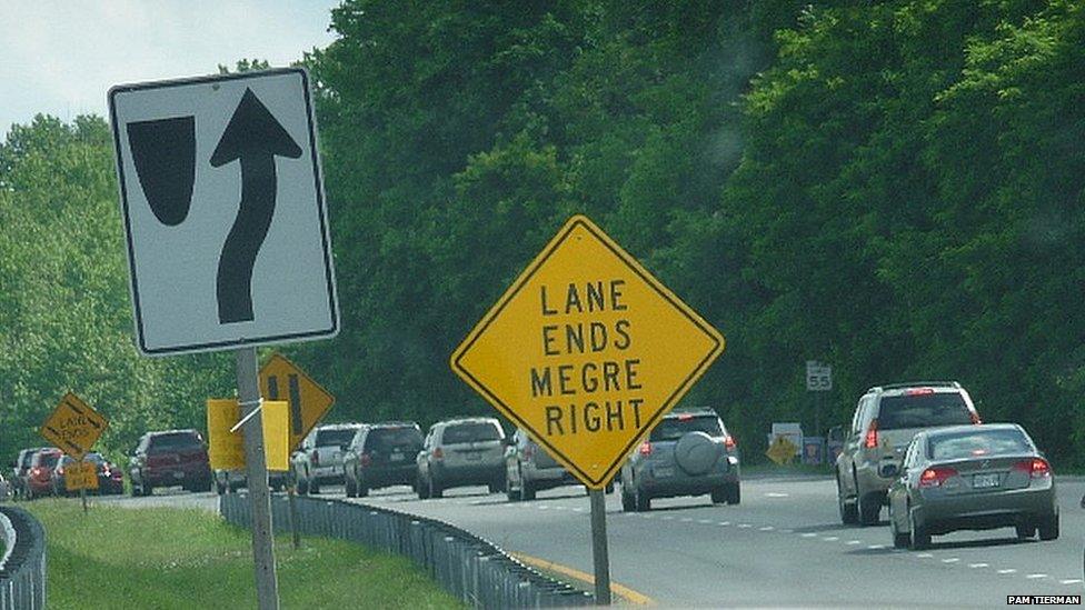 The road sign has misspelt: "Lane ends megre right"