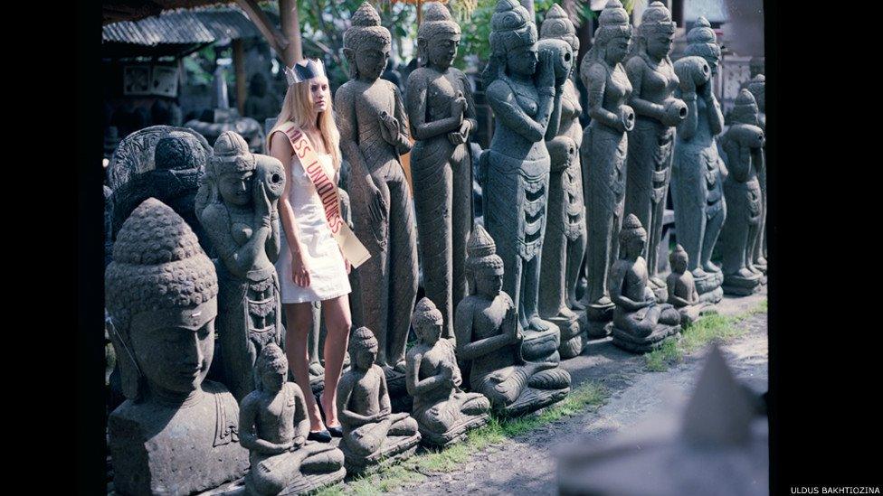Women dressed as 'Miss Uniqueness' lined up among stone statues