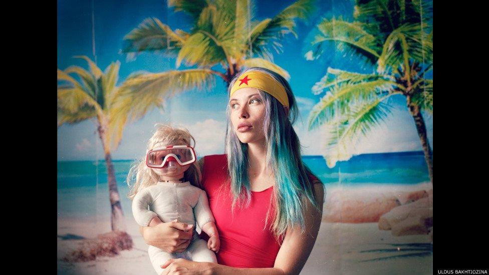 Woman holding baby with a snorkel mask on