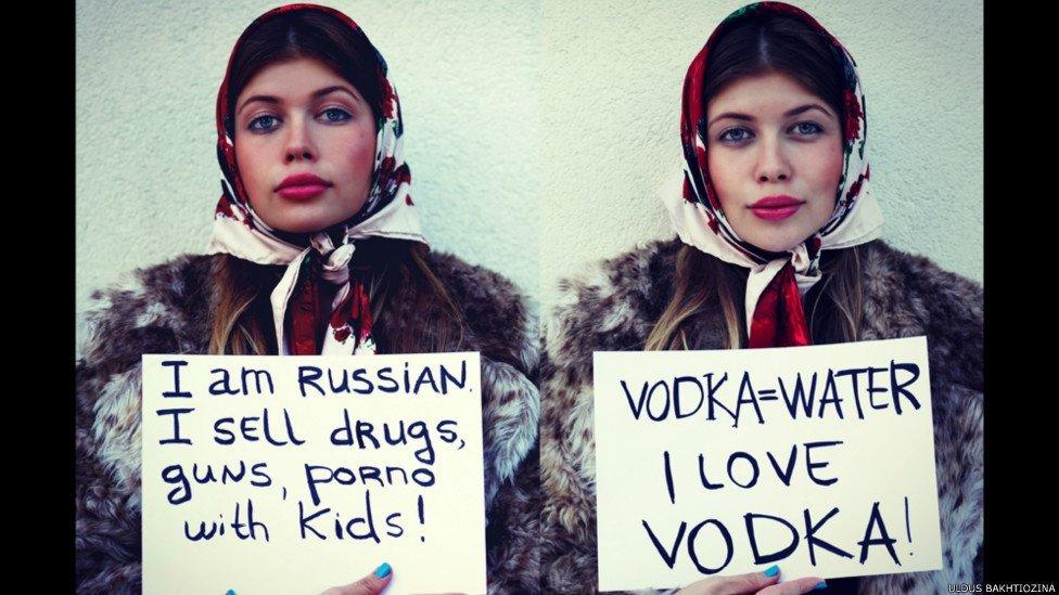One woman holding a sign saying 'I am Russian I sell drugs' and another holding up a sign saying 'Vodka water'