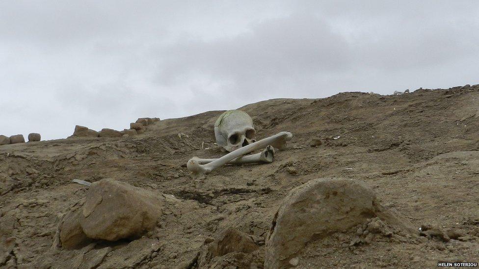 A skull and bone can be seen lying on a mound of sand at Huaca Malena