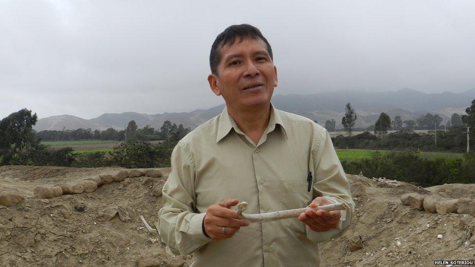 Rommel Angeles Falcon holds a bone at Huaca Malena