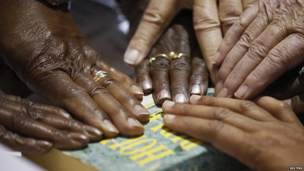 Hands of poll workers on a Bible as head precinct judge reads them the oath before opening the polls at the Grove Presbyterian Church in Charlotte, North Carolina.