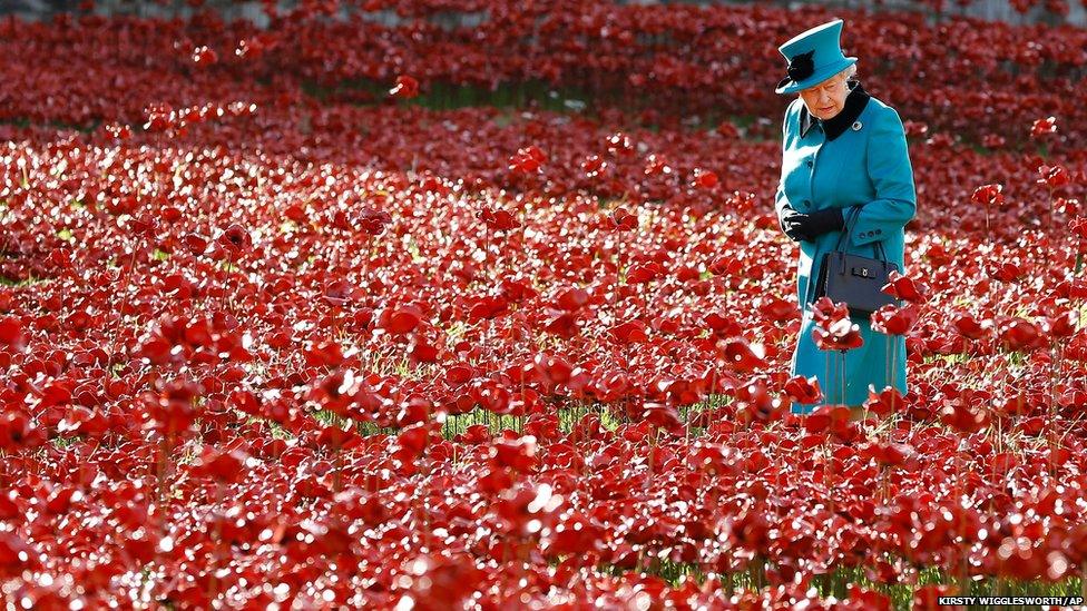 Britain's Queen Elizabeth II walks through a field of ceramic poppies