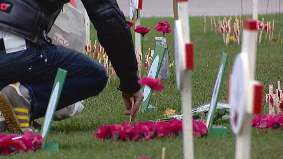 Man plants a cross of remembrance