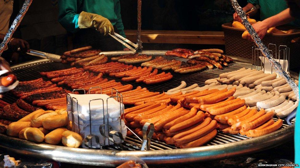 Market staff prepare Bratwurst