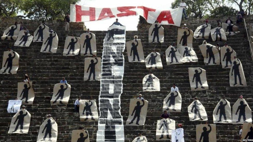 Activists hold painted silhouettes representing the 43 missing students, while performing a symbolic blockade of a pyramid at the archaeological site of Monte Alban in Oaxaca on 12 November, 2014