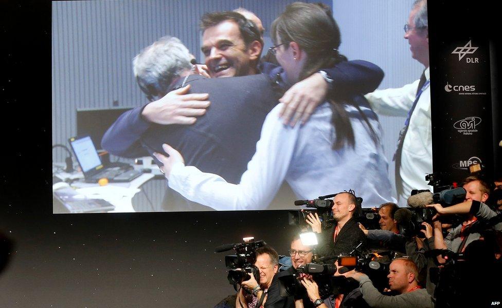 Journalists film near giant screen at mission control in Darmstadt