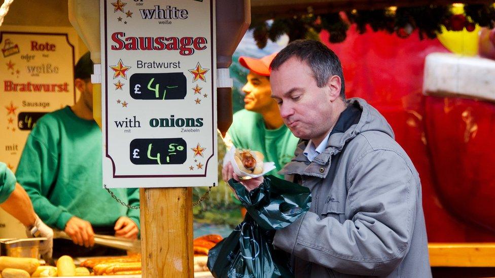 A man buys a bratwurst at the Christmas market