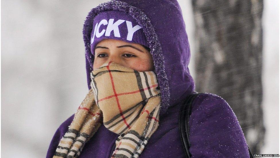 A woman wrapped up ahead of a snowstorm