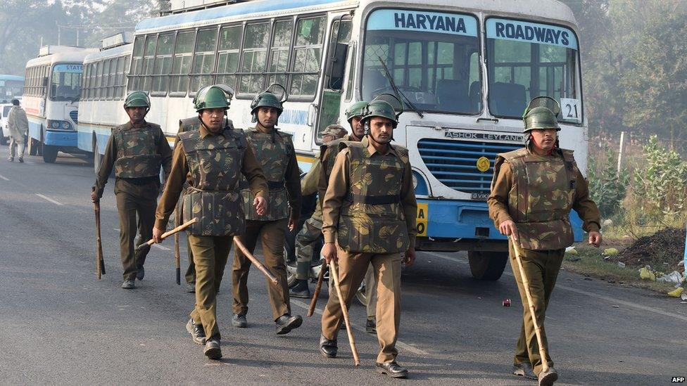 Indian police personnel walk towards the ashram of self-styled "godman" Rampal Maharaj in Hisar, some 175 kilometres (108 miles) north of New Delhi on November 19, 2014.